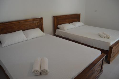 two beds in a room with towels on them at Shim Beach Resort in Arugam Bay