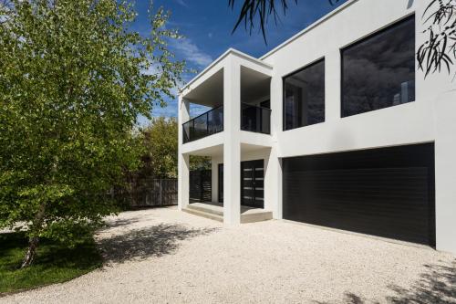 a white house with a garage at Pearl Hawley Beach in Port Sorell