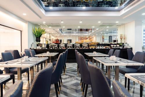 a restaurant with tables and chairs in a room at SureStay Hotel by Best Western Vientiane in Vientiane