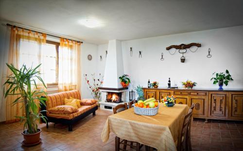 een woonkamer met een tafel en een open haard bij Agriturismo Pescaia in Montepulciano