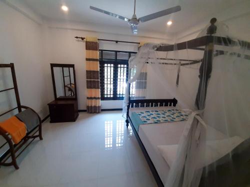 a bedroom with a bed and a ceiling fan at Hill House Rest in Mirissa