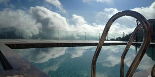 a pool with a reflection of the sky in the water at Regenta Place Green Leaf Mahabaleshwar in Mahabaleshwar