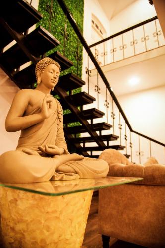 a statue of a man sitting on a table in a museum at Regenta Place Green Leaf Mahabaleshwar in Mahabaleshwar