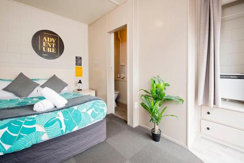 a bedroom with a bed and a bathroom at Bridge Backpackers in Nelson