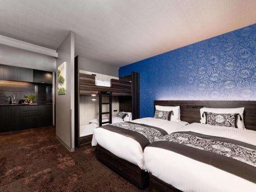 a bedroom with two beds and a blue wall at MIMARU Tokyo Ginza East in Tokyo