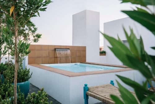 a hot tub in a garden with a chair at Nuzl Shada Hotel in Jeddah