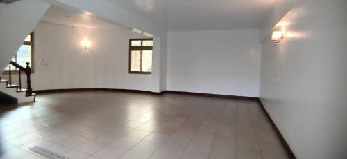 an empty room with white walls and a tile floor at Wen Mei Motel in Nantou City