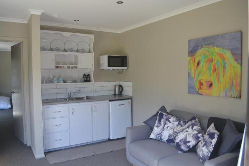a living room with a couch and a kitchen at Highlands on Homestead in Oamaru