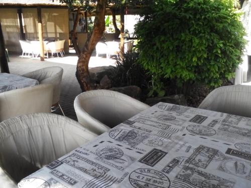 a table with chairs and a table cloth on it at Gabbata Lodge in Leeuwfontein
