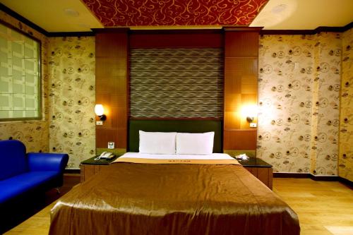 南投市的住宿－溫美汽車旅館，酒店客房,配有床和蓝色的沙发