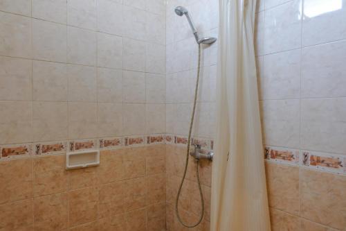een douche met een douchegordijn in de badkamer bij Super OYO 1803 Hotel Sarangan Permai in Madiun