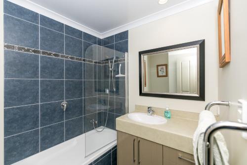 a bathroom with a sink and a tub and a mirror at Daffodil Bed and Breakfast in Hamilton