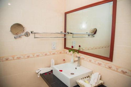 a bathroom with a sink and a mirror at Palace Hotel Arusha in Arusha