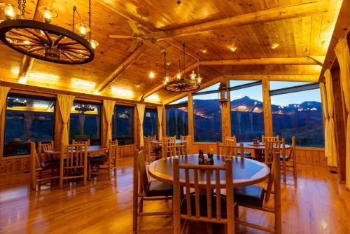 a dining room with tables and chairs and windows at Twin Peaks Guest Ranch in Salmon