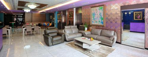uma sala de estar com um sofá, cadeiras e uma mesa em Lily Hotel em Kaohsiung