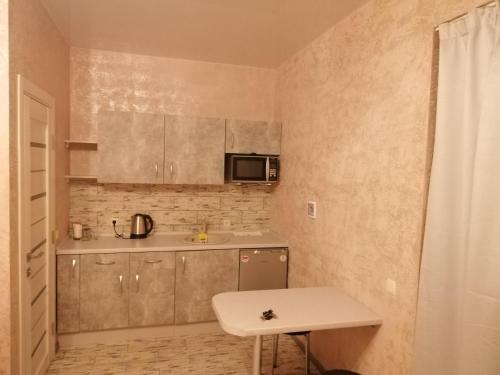 a small kitchen with a sink and a microwave at Гостьовий будинок Осокорки in Kyiv