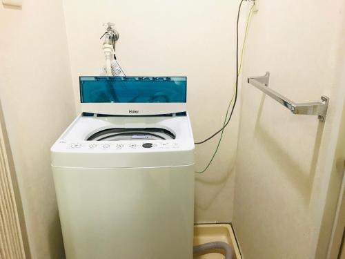 a washer and dryer in a corner of a room at HOTEL MYSTAYS Otemae in Osaka