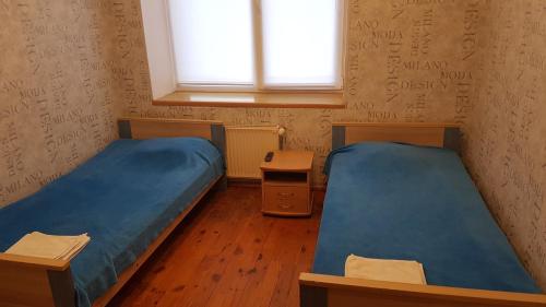 a room with two beds and a window at Hotel Erfolg in Daugavpils