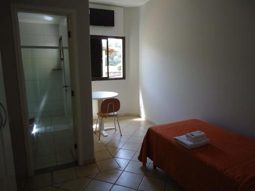 a bedroom with a shower and a bed and a table at Big Executive Hotel in Araguari