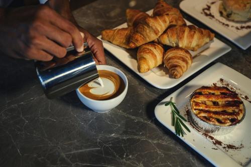 a person is making a cup of coffee and pastries at iSanook Resort & Suites Hua Hin in Hua Hin