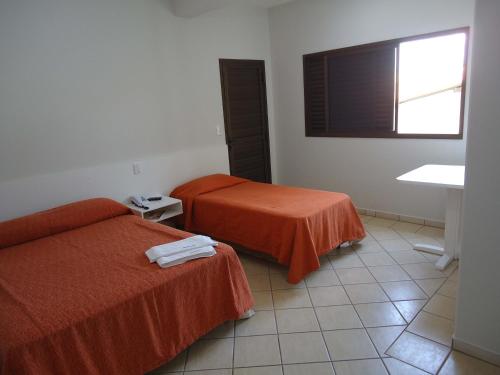 a hotel room with two beds and a television at Big Executive Hotel in Araguari