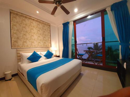 a bedroom with a bed with a view of the ocean at Huvan Beach Hotel at Hulhumale in Hulhumale