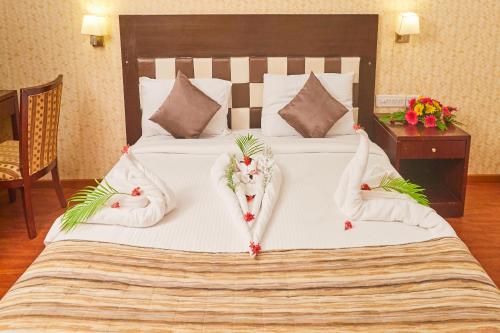a bedroom with a large white bed with flowers on it at Esthell Village Resort in Mahabalipuram