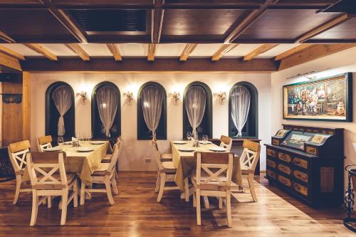 a dining room with tables and chairs and windows at Casa Comana Boutique Hotel in Bucharest