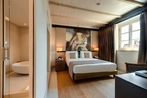 a hotel room with a bed and a bath tub at Villa Agrippina Gran Meliá – The Leading Hotels of the World in Rome