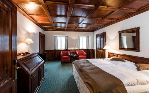 a hotel room with a bed and a desk and chairs at Romantik Hotel Zur Schwane in Volkach