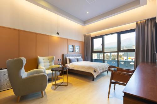 慶州市にあるBrown Dot Hotel Gyeongjuのベッドと椅子付きのホテルルーム