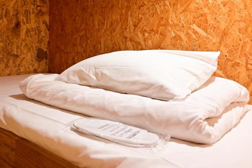 a bed with a pillow and a napkin on it at Kawaramachi Domitory in Takamatsu