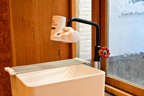 a white microwave sitting next to a window at Kawaramachi Domitory in Takamatsu