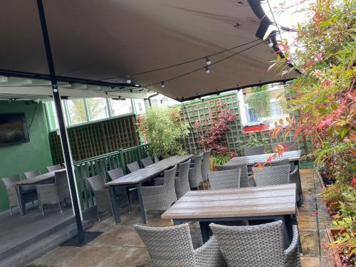 an outdoor patio with tables and chairs and an umbrella at Black Lion in Surbiton