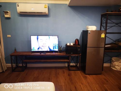 a television sitting on a table next to a refrigerator at Terrua Main Ten Villa Garden in Suan Phung