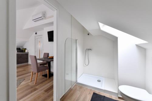 a bathroom with a shower and a toilet and a table at Villa Oliver 2 Siófok in Siófok