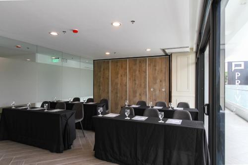 a room with rows of tables and chairs in it at Privato Makati in Manila