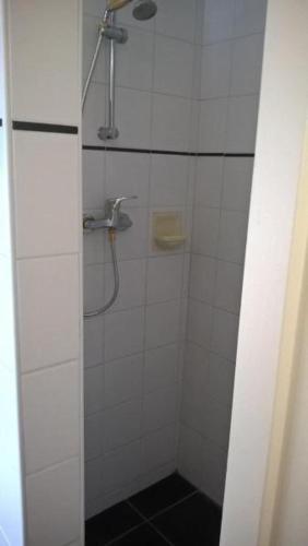 a bathroom with a shower with a glass door at boerderijkamer Korenbloem in Onstwedde