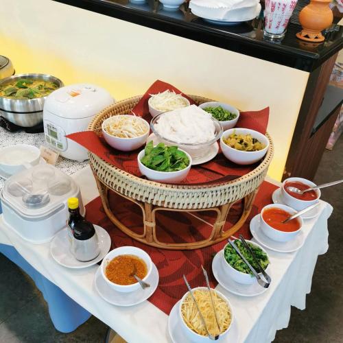 a table with bowls of food on a table at Coco View Hotel in Samut Songkhram