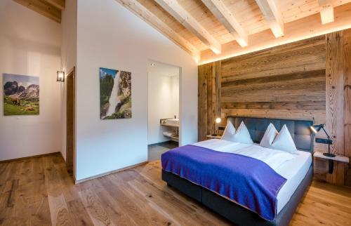 a bedroom with a large bed and wooden ceilings at Almdorf Almlust in Flachau