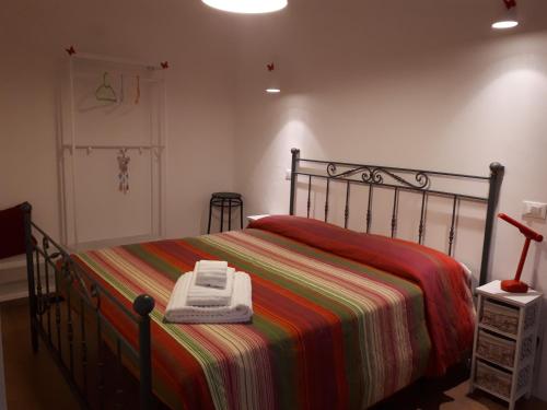 een slaapkamer met een bed met een gestreepte deken bij B&b Campus in Parma