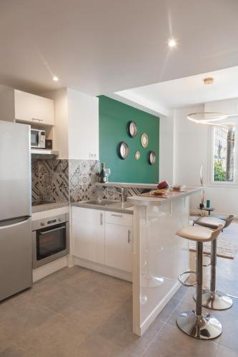 - une cuisine avec des placards blancs et un mur vert dans l'établissement Beautiful apartment in the heart of Nice, à Nice