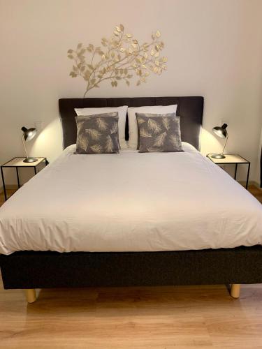 une chambre avec un grand lit avec deux lampes dans l'établissement Appartements des 2 Têtes, à Colmar