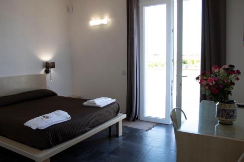 a bedroom with a bed and a door to a balcony at La Mela Di Venere in Palazzolo Acreide