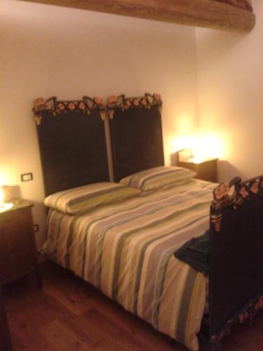 a bedroom with a bed with two lights on at Alloggio Agrituristico Conte Ottelio in Pradamano