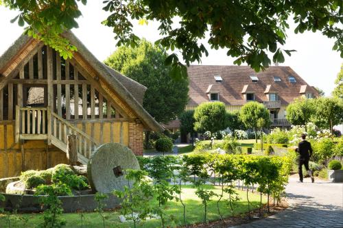 a man walks past a house with a garden at La Ferme Saint Simeon Spa - Relais & Chateaux in Honfleur