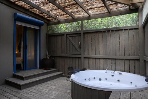 a bathroom with a bath tub on a deck at Bar Bakfar in Sharona
