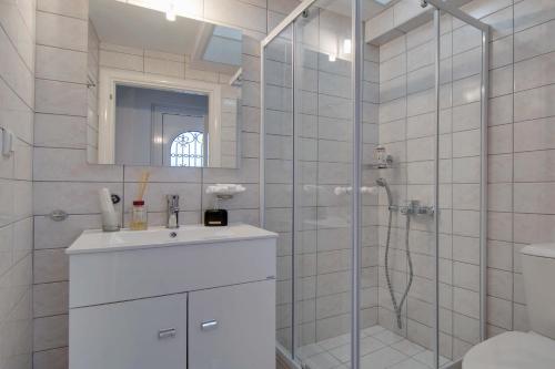 een badkamer met een douche, een wastafel en een toilet bij Holiday Home in Ioannina