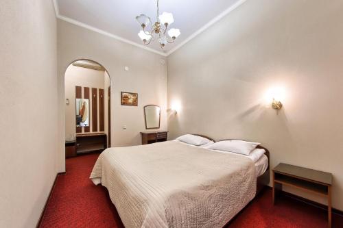 een slaapkamer met een wit bed en een spiegel bij Antares on Nevsky Prospect in Sint-Petersburg
