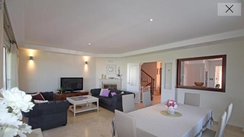 a living room with a couch and a table at Marbella Deluxe Rooms in Royal Cabopino Townhouse in Marbella